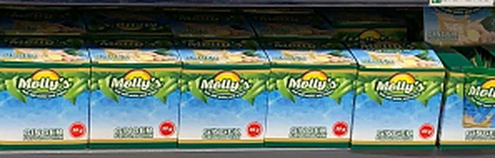 A shelf stocked with Molly's Ginger display boxes